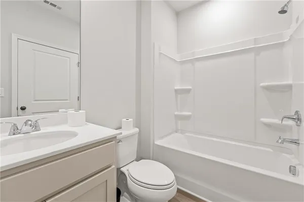 a bathroom with a sink toilet vanity and shower