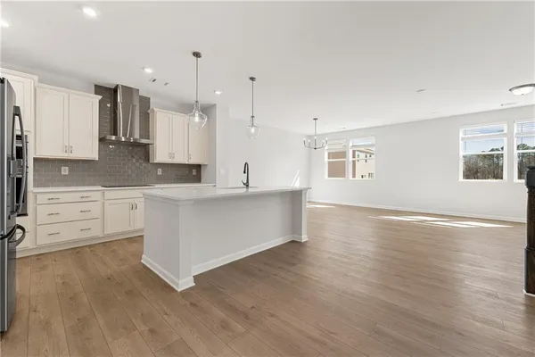 a large white kitchen with cabinets and wooden floor
