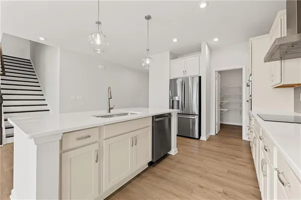 a kitchen with white cabinets and stainless steel appliances