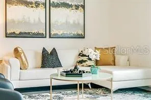 a living room with furniture a flat screen tv and a large window