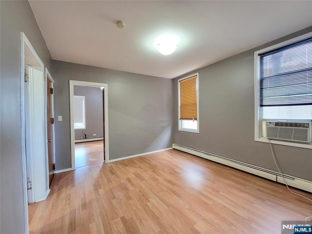 6 6th Street Harrison, NJ 07029 - Photo 2 of 12 a view of empty room with wooden floor and fan