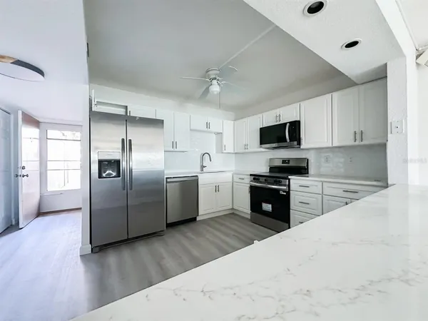 a kitchen with stainless steel appliances a refrigerator sink and microwave