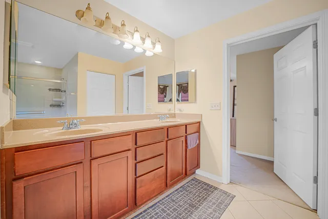 a spacious bathroom with a double vanity sink a mirror and a