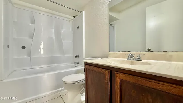 a bathroom with a granite countertop sink a toilet and shower