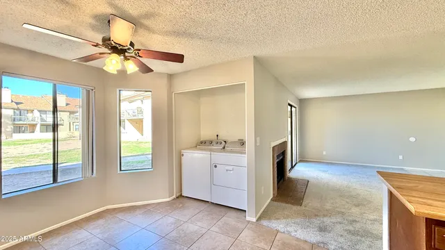 a view of a livingroom with a chandelier fan and windows