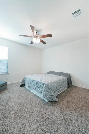 a bedroom with a bed and a ceiling fan