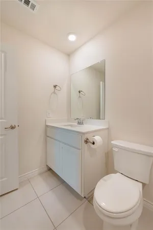 a bathroom with a toilet a sink a mirror and vanity