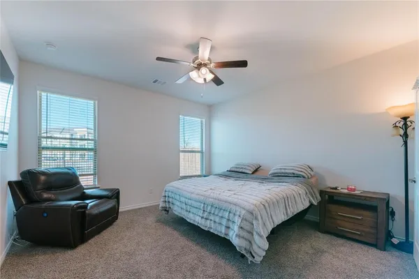 a bedroom with bed couch and window