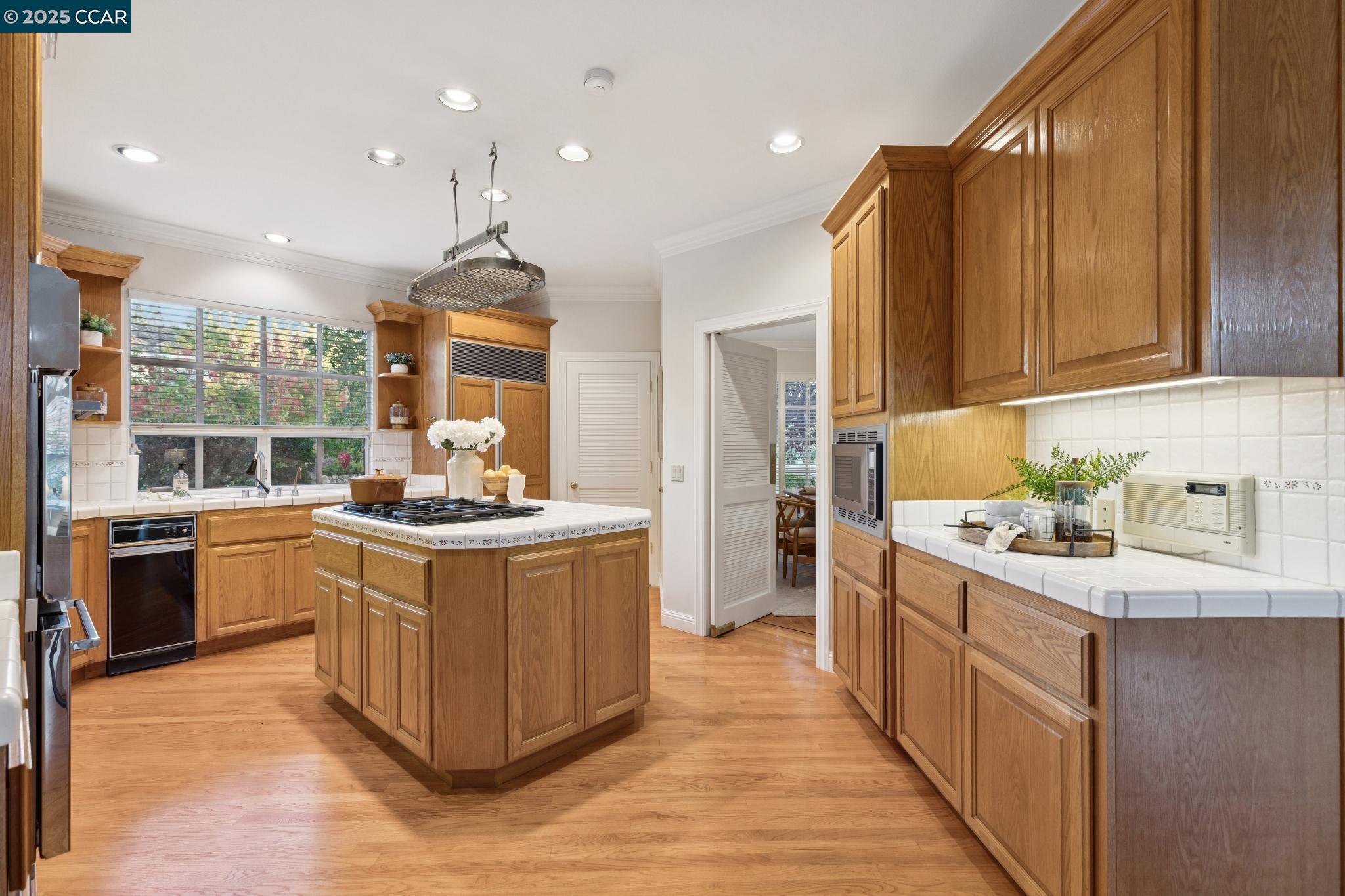 788 Woodwind Place Walnut Creek, CA 94598 - Photo 13 of 48 a kitchen with stainless steel appliances granite countertop a stove top oven a sink dishwasher a refrigerator and a dining table with wooden floor