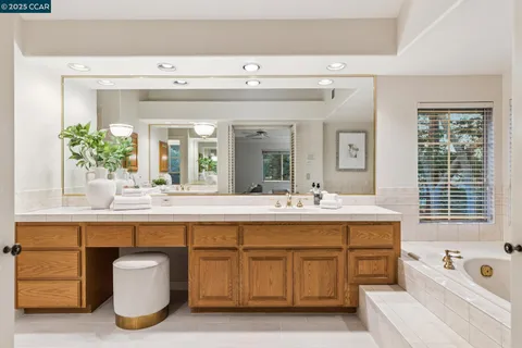 a bathroom with a tub sink and mirror