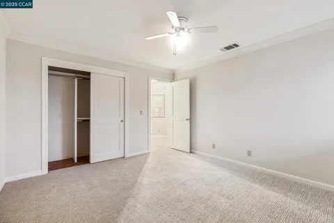 an empty room with a window and a ceiling fan