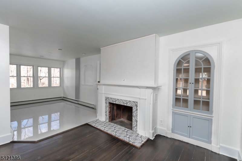 636 Valley Road Watchung, NJ 07069 - Photo 19 of 43 a view of an empty room with exposed radiator and fireplace