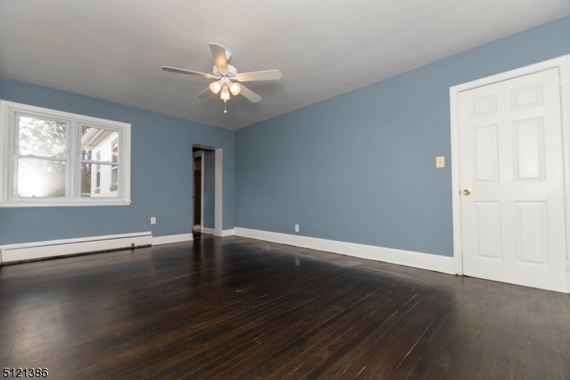 636 Valley Road Watchung, NJ 07069 - Photo 25 of 43 an empty room with wooden floor chandelier fan and windows