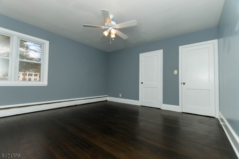 636 Valley Road Watchung, NJ 07069 - Photo 27 of 43 an empty room with wooden floor chandelier fan and windows