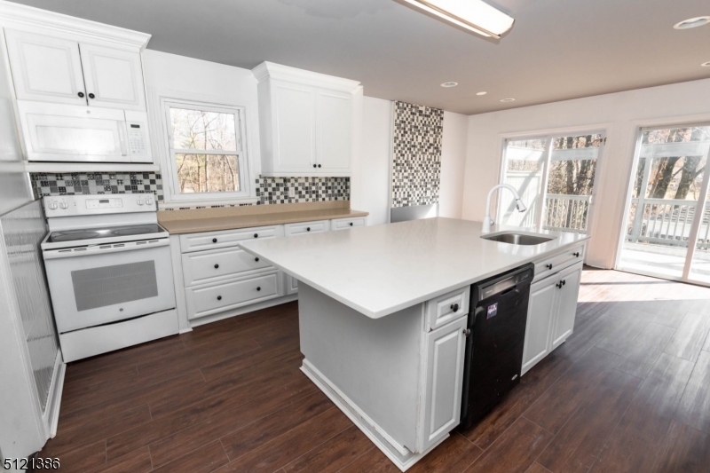 636 Valley Road Watchung, NJ 07069 - Photo 8 of 43 a kitchen with granite countertop white cabinets and white appliances
