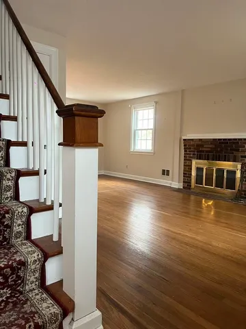 a dining room with chandelier and wooden floor