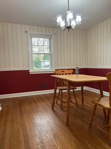 a view of a refrigerator in kitchen and an empty room