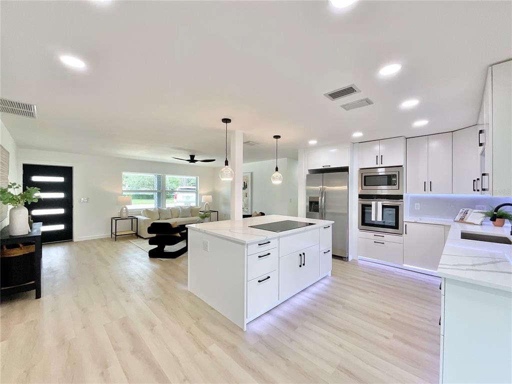 1290 Michigan Boulevard Dunedin, FL 34698 - Photo 11 of 45 a large white kitchen with stainless steel appliances