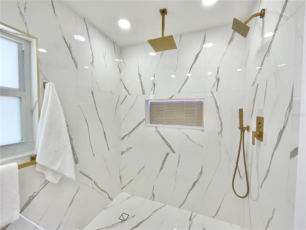 1290 Michigan Boulevard Dunedin, FL 34698 - Photo 17 of 45 a bathroom with a bathtub and a shower