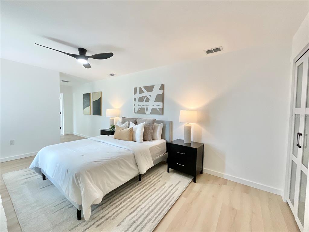 1290 Michigan Boulevard Dunedin, FL 34698 - Photo 22 of 45 a bedroom with a bed and a painting on the wall