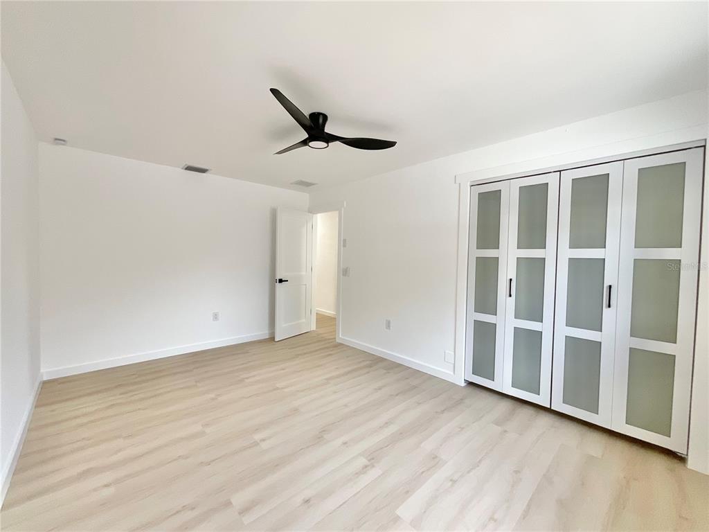 1290 Michigan Boulevard Dunedin, FL 34698 - Photo 25 of 45 an empty room with wooden floor and windows