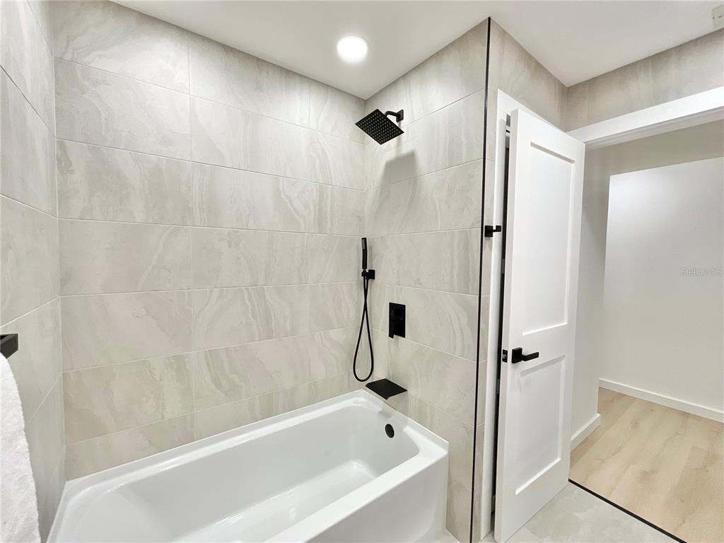1290 Michigan Boulevard Dunedin, FL 34698 - Photo 27 of 45 a bathroom with a bathtub and a shower