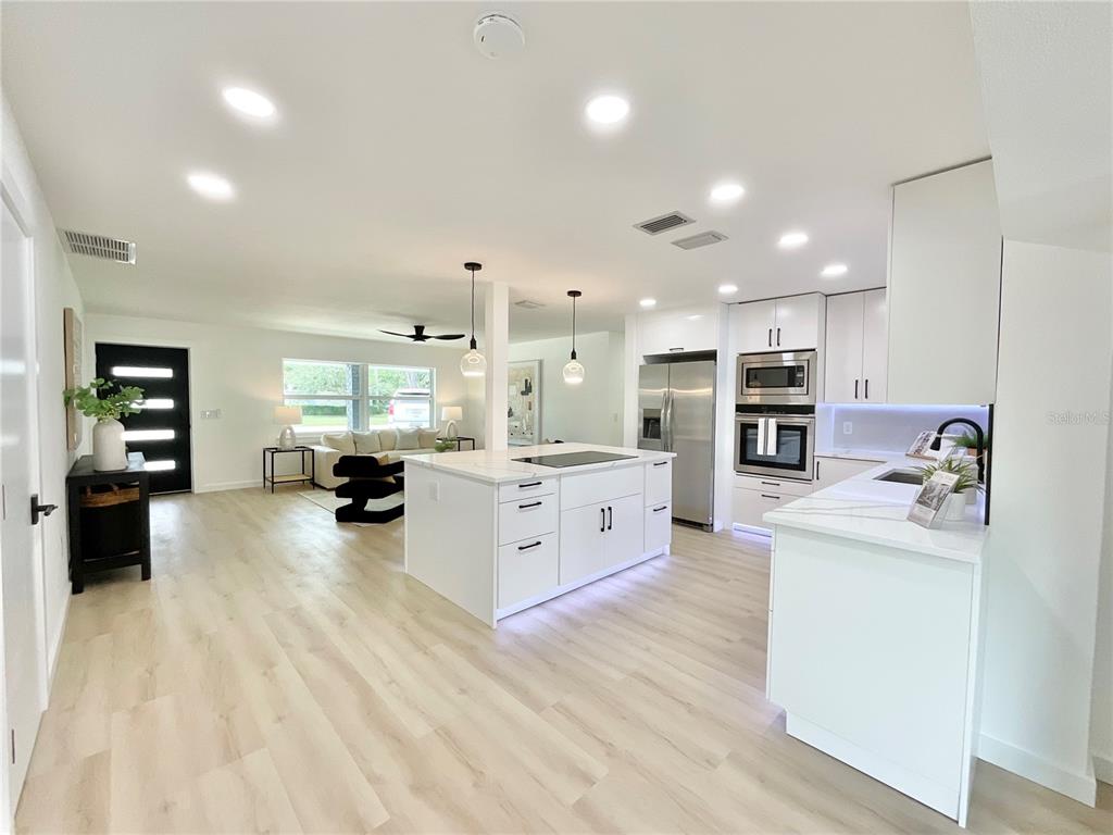 1290 Michigan Boulevard Dunedin, FL 34698 - Photo 3 of 45 a large white kitchen with a large window and stainless steel appliances