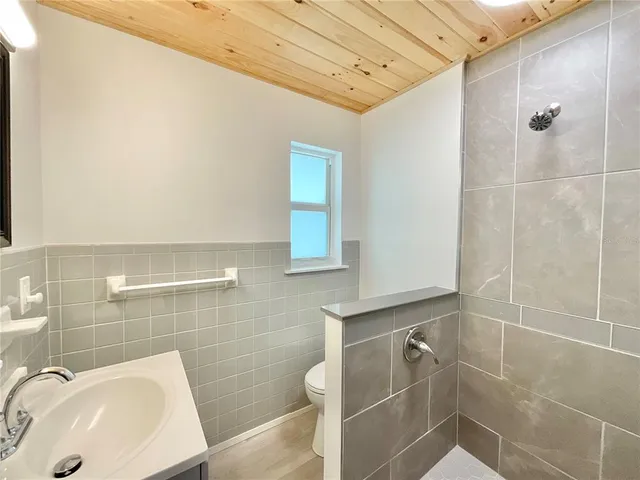 a bathroom with a sink a toilet and shower