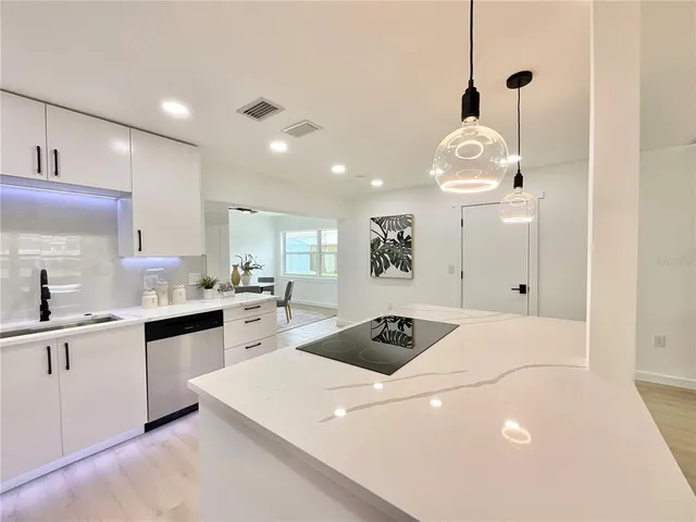 a kitchen that has a lot of cabinets and wooden floor