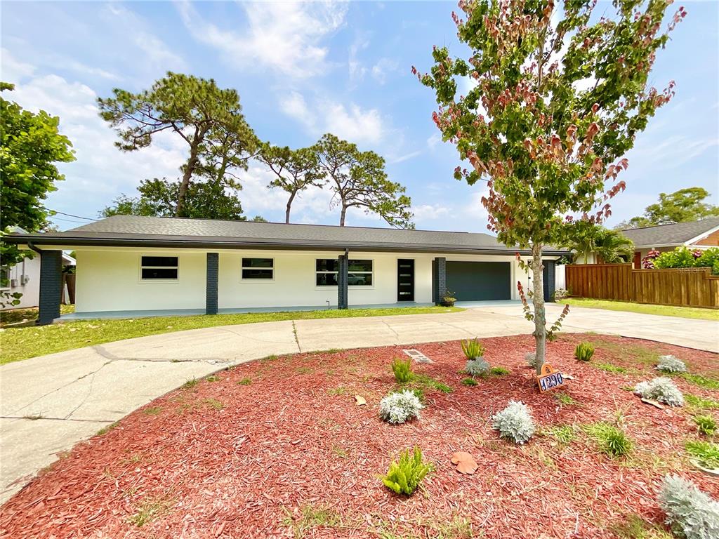 1290 Michigan Boulevard Dunedin, FL 34698 - Photo 43 of 45 a front view of a house with a yard and garage