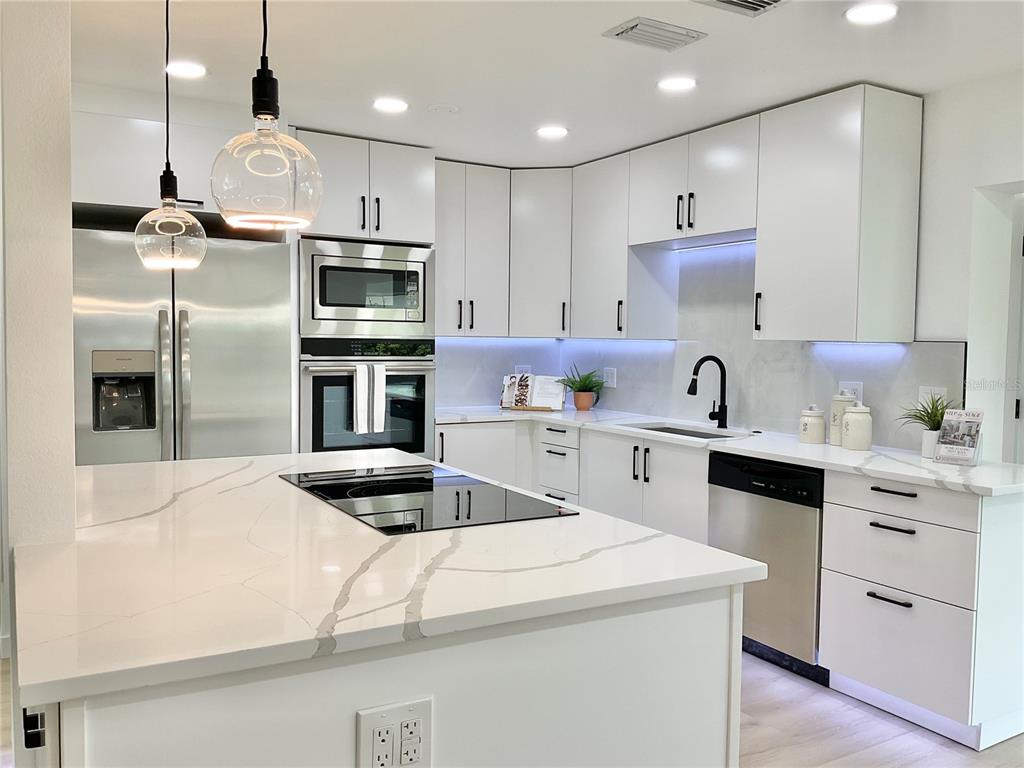 1290 Michigan Boulevard Dunedin, FL 34698 - Photo 5 of 45 a kitchen with kitchen island a sink stainless steel appliances and cabinets