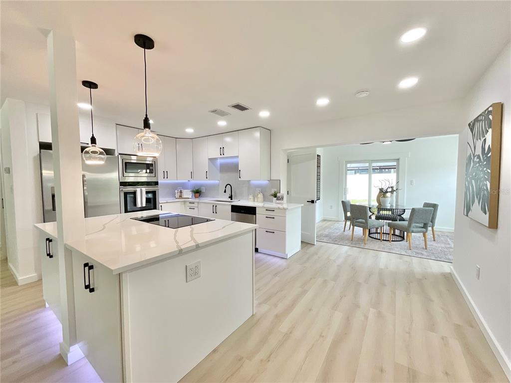 1290 Michigan Boulevard Dunedin, FL 34698 - Photo 6 of 45 a kitchen with stainless steel appliances kitchen island granite countertop a sink and refrigerator