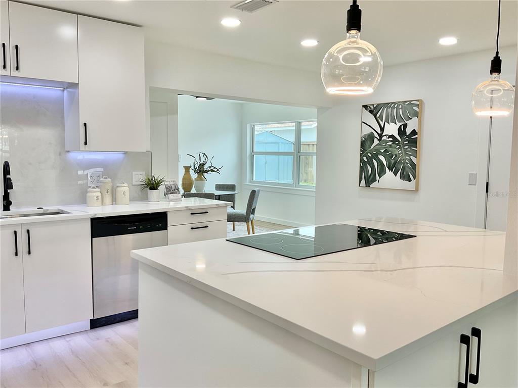 1290 Michigan Boulevard Dunedin, FL 34698 - Photo 7 of 45 a kitchen with stainless steel appliances a stove a sink cabinets and a refrigerator