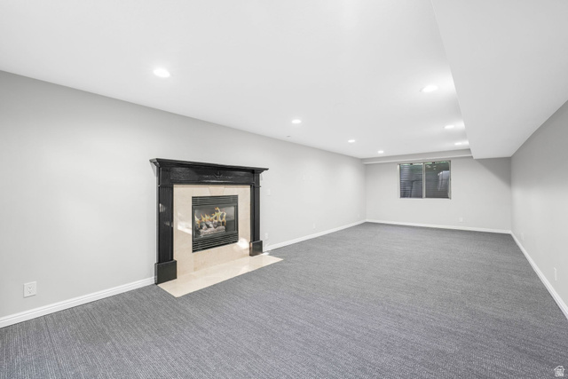 8965 Quail Run Drive Sandy, UT 84093 - Photo 23 of 56 Finished basement with carpet, a tiled fireplace, and recessed lighting
