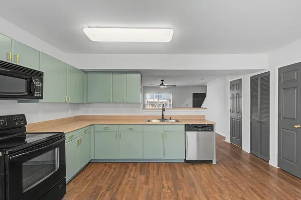 a view of a kitchen with a sink and wooden floor