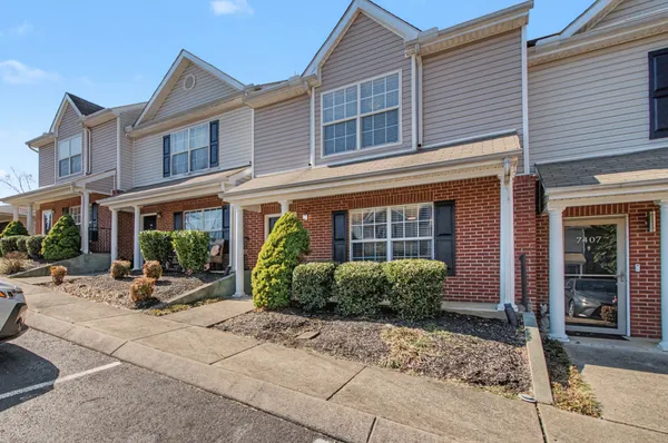 a view of a brick building with large windows and potted plants