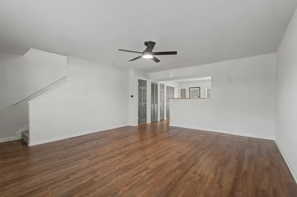 a living room with stainless steel appliances wooden floor and large window