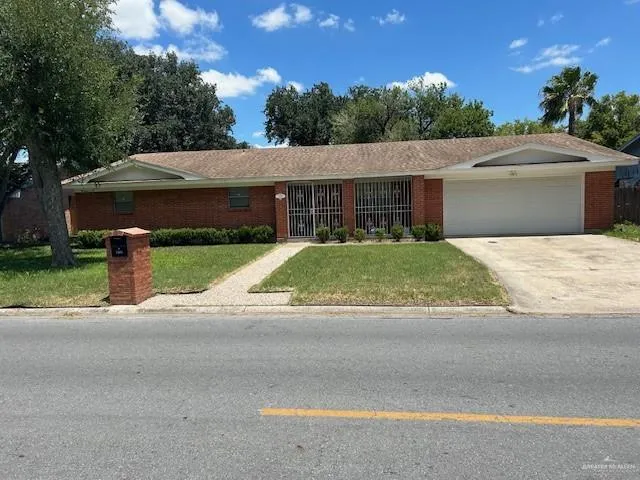 a view of a house with a yard and potted plants