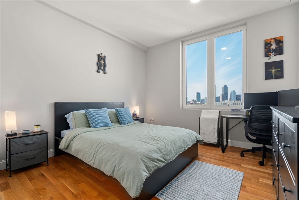 10 Taber Street, Unit 608 Boston, MA 02119 - Photo 14 of 20 a bedroom with a bed a table and chair