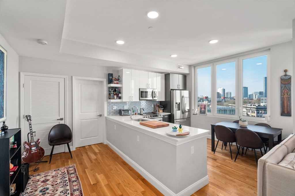 10 Taber Street, Unit 608 Boston, MA 02119 - Photo 9 of 20 a dining room with furniture and a chandelier