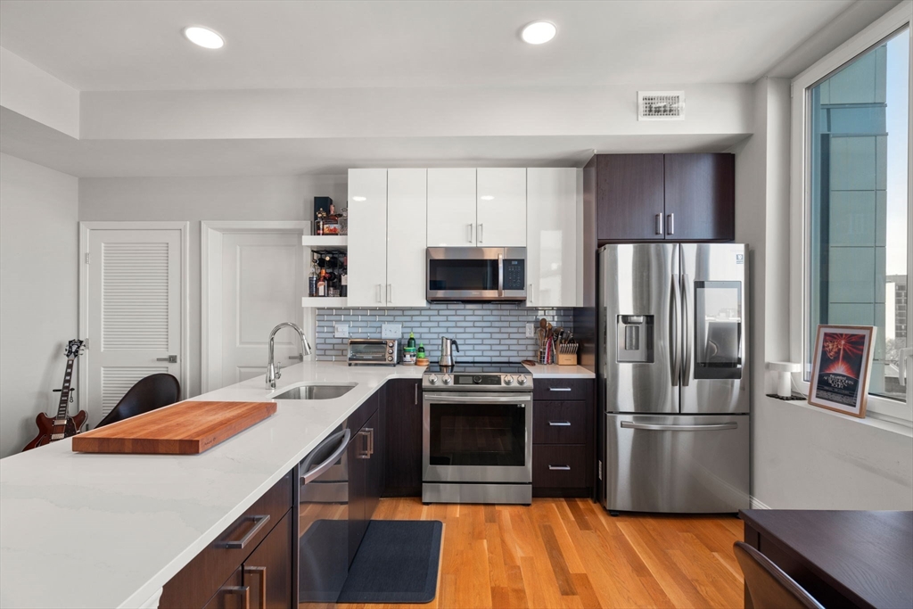 10 Taber Street, Unit 608 Boston, MA 02119 - Photo 10 of 20 a kitchen with stainless steel appliances a sink stove refrigerator and cabinets