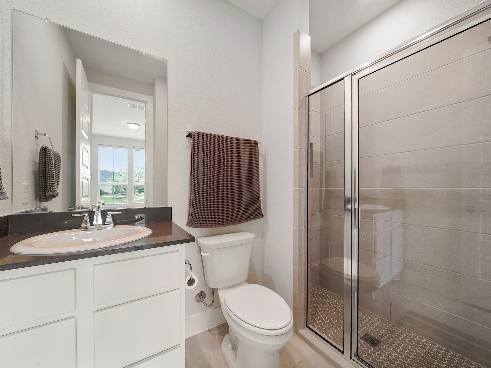 5802 Emerald Ranch Lane Fulshear, TX 77441 - Photo 8 of 45 The ensuite guest bathroom features modern finishes, generous counter space, and a sleek walk-in shower that creates a polished and comfortable experience for guests.