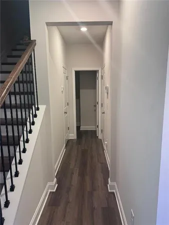 a view of a hallway with wooden floor and staircase