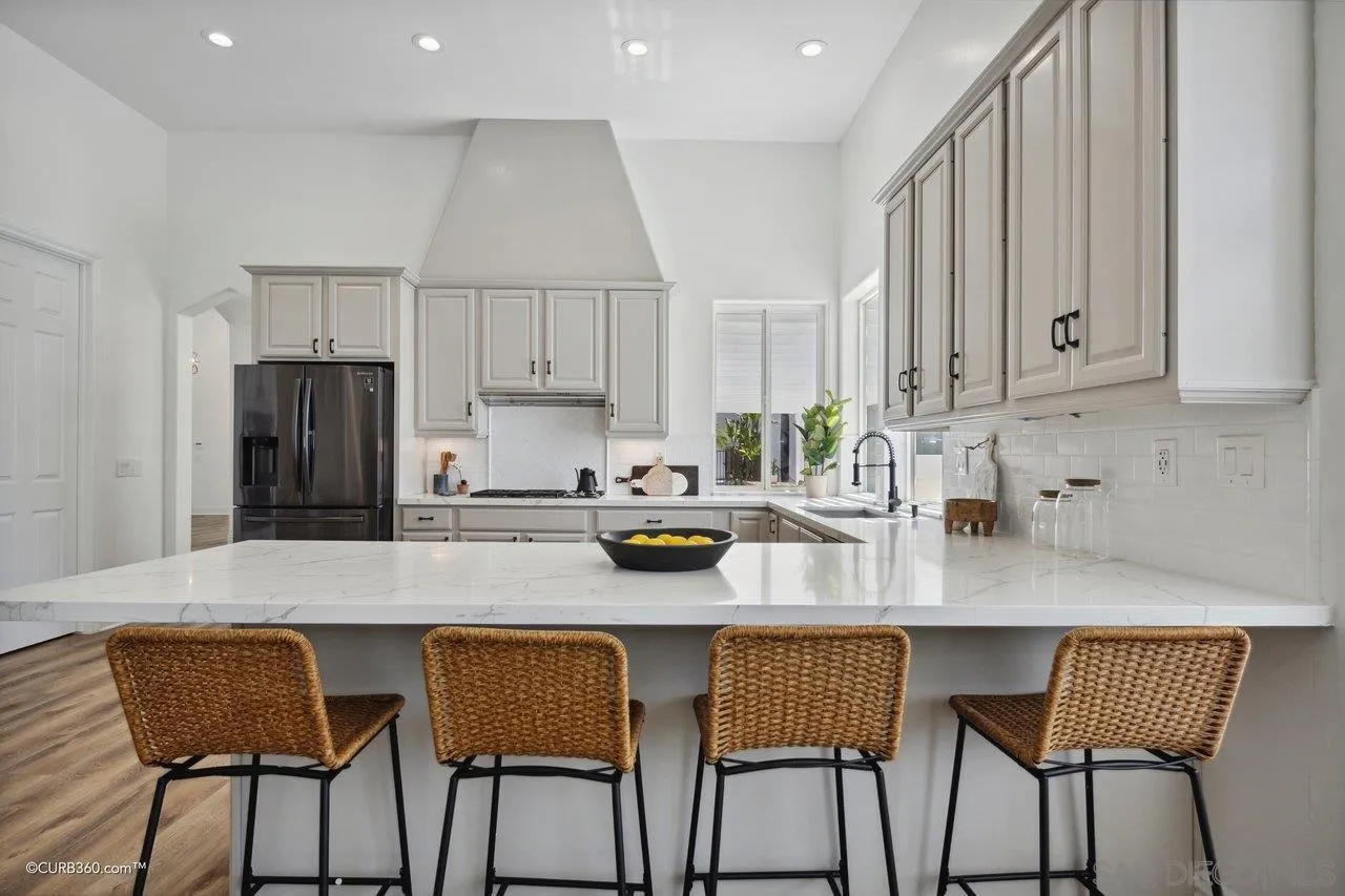 17035 Edina Court Poway, CA 92064 - Photo 13 of 52 a kitchen with stainless steel appliances granite countertop a table and chairs in it