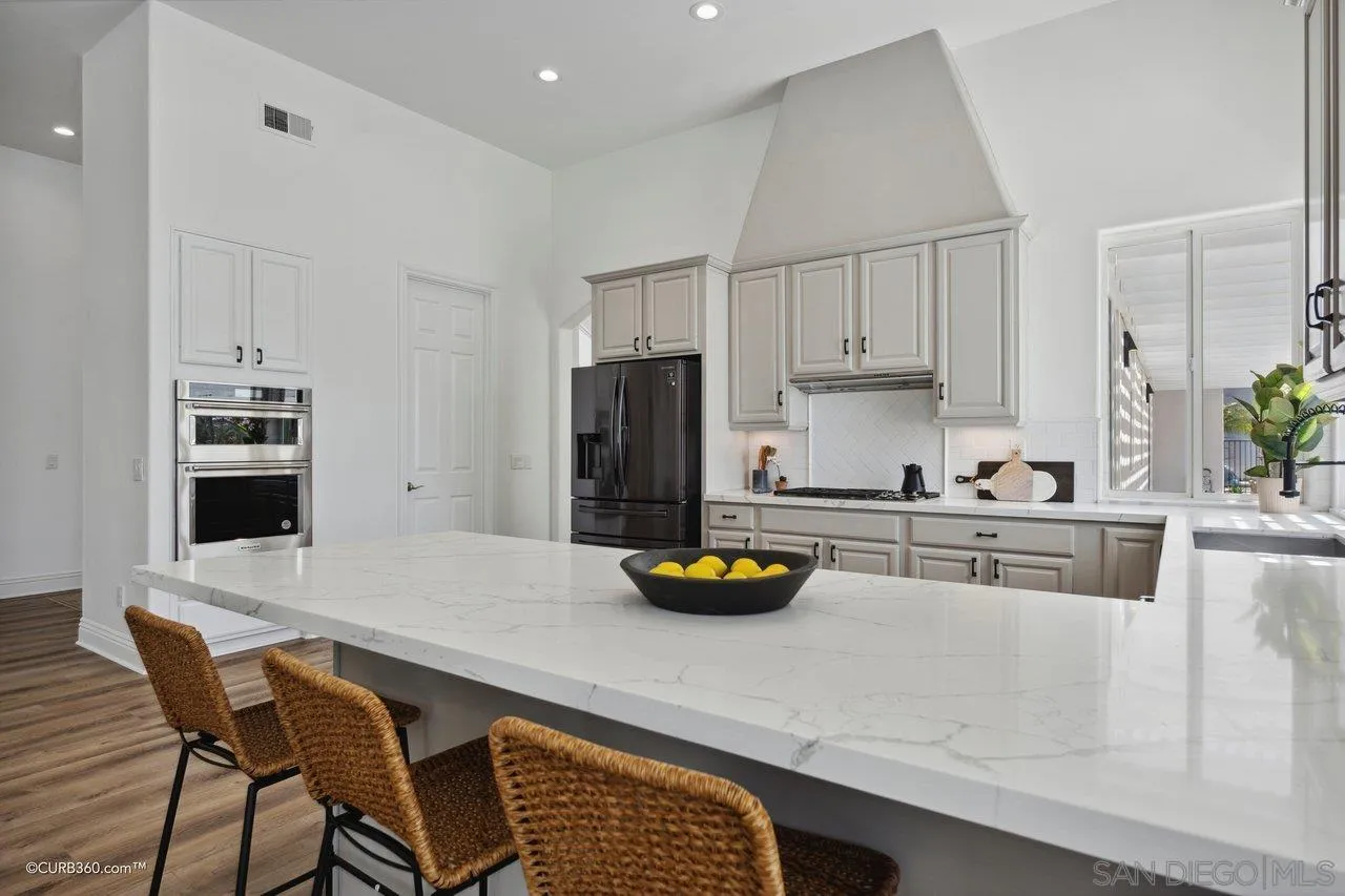 17035 Edina Court Poway, CA 92064 - Photo 14 of 52 a kitchen with a sink a stove and white cabinets