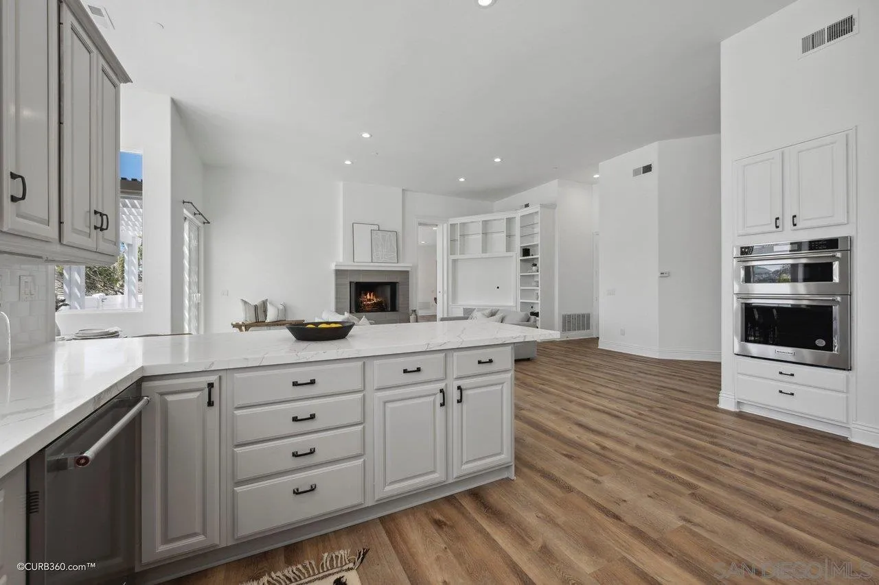 17035 Edina Court Poway, CA 92064 - Photo 16 of 52 a kitchen with stainless steel appliances a refrigerator sink and white cabinets