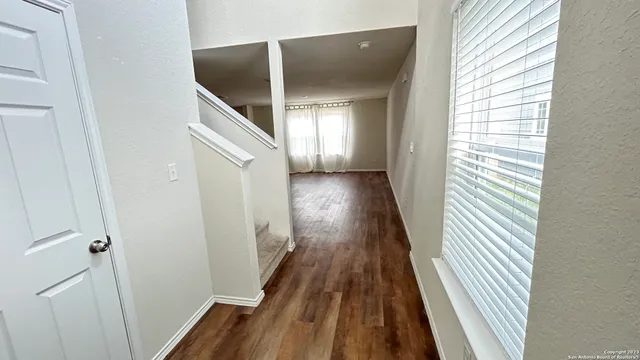 a view of a hallway with wooden floor and staircase