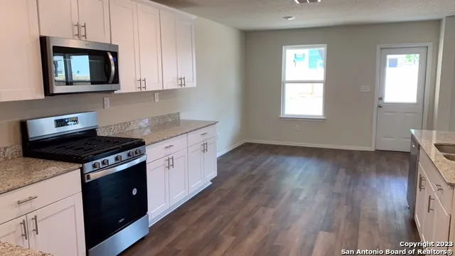 a kitchen with wooden floors and appliances