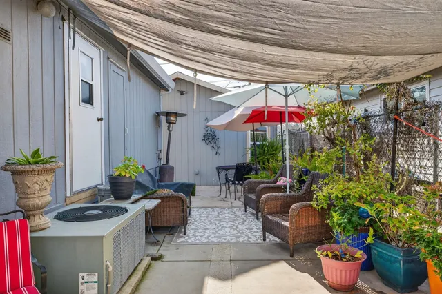 a view of a patio with a table and chairs under an umbrella