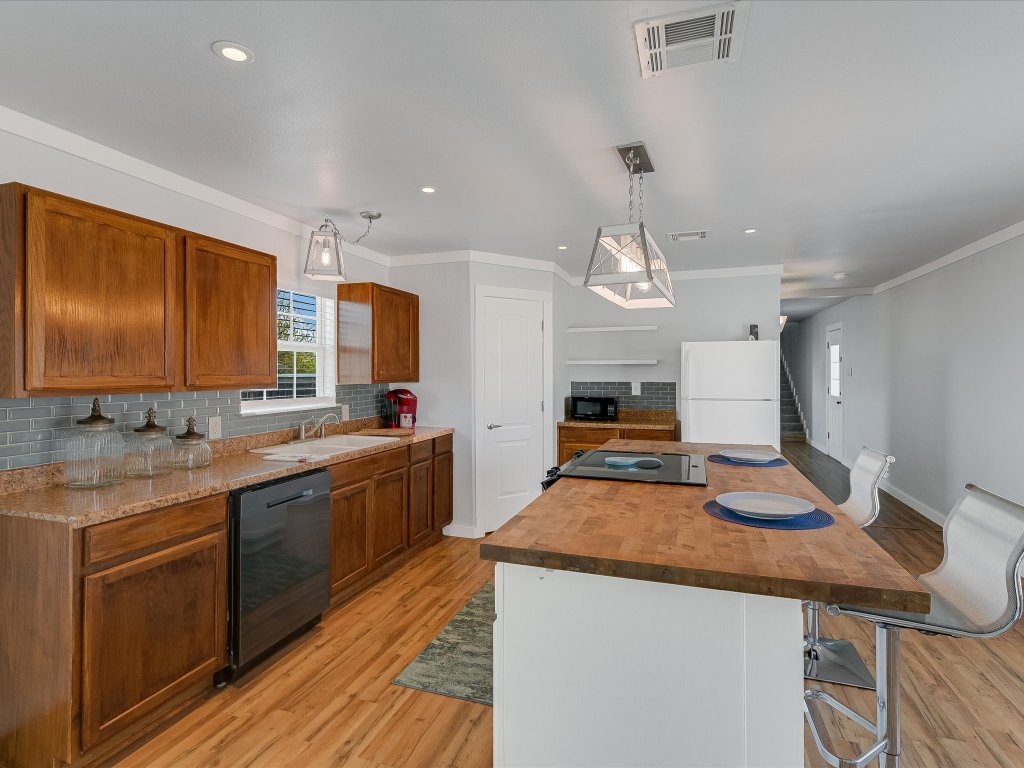 155 Travis Lane Spicewood, TX 78669 - Photo 4 of 33 a large kitchen with granite countertop a stove and cabinets